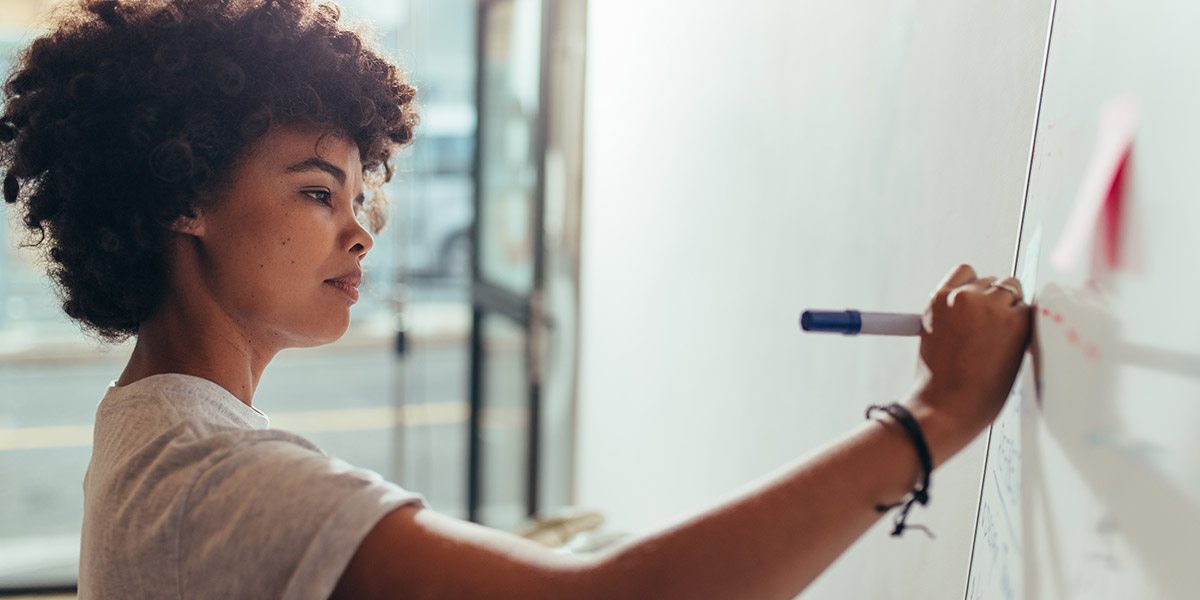 Female software engineer using whiteboard