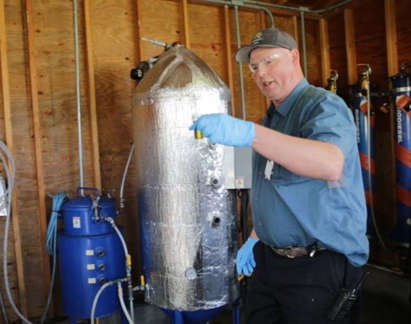Person demonstrating On-site biodiesel conversion apparatus