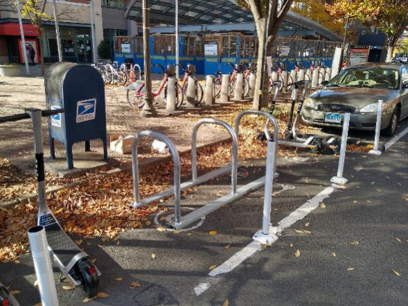 Picture of a micromobility corral which combines bike racks and open space for dockless bikes or escooters