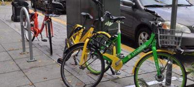Picture of 3 brands of dockless bikeshare bikes on a sidewalk