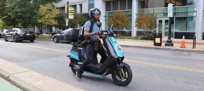 Photo of a person riding a Revel electric moped
